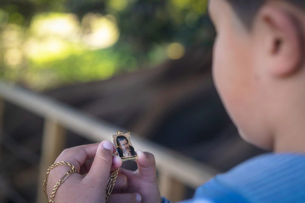 Fotografía de niño mirando una imagen en una cadena.